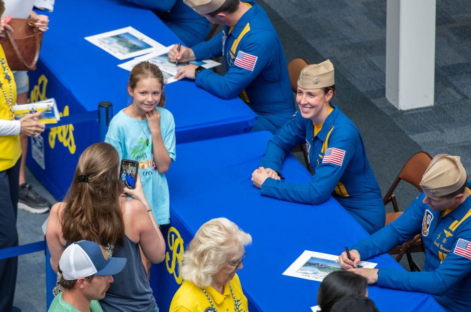 Hadley Gaynor, 11, of Cheboygan, Michigan, center, poses for a photo with Lt. Amanda Lee in the National Naval Aviation Museum after the Blue Angels practice at NAS Pensacola on Wednesday, May 17, 2023.