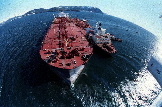 FILE - In this April 4, 1989, file photo, the grounded tanker Exxon Valdez, left, unloads oil onto a smaller tanker, San Francisco, as efforts to re-float the ship continue on Prince William Sound, 25 miles from Valdez, Alaska. The 987-foot tanker, carrying 53 million gallons of crude, struck Bligh Reef at 12:04 a.m. on March 24, 1989, and within hours unleashed an estimated 10.8 million gallons of thick, toxic crude oil into the water. Storms and currents then smeared it over 1,300 miles of shoreline. Twenty five years later, the region, its people and its wildfire are still recovering. (AP Photo, File)