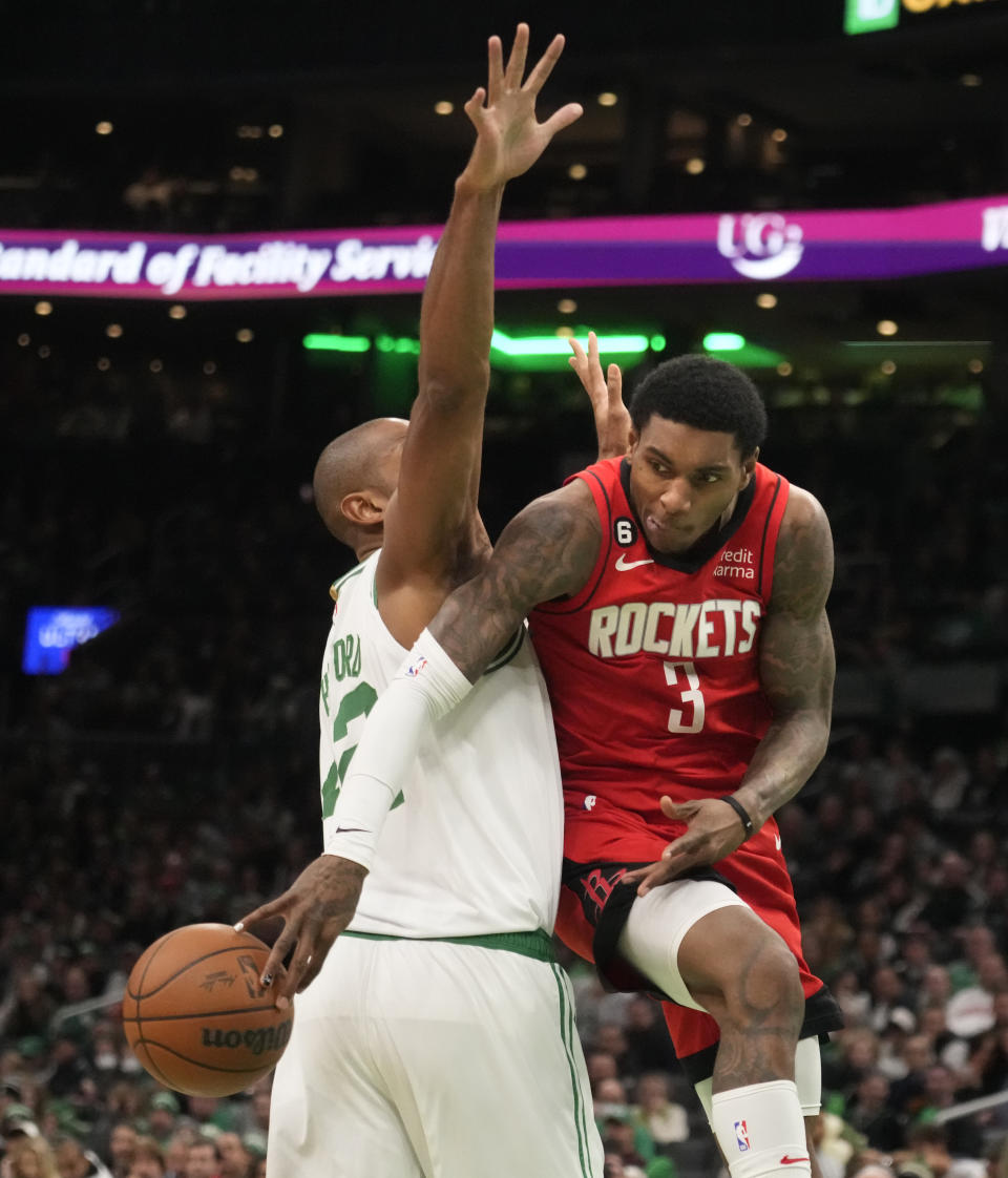 Houston Rockets guard Kevin Porter Jr. (3) passes the ball behind the back of Boston Celtics center Al Horford during the second half of an NBA basketball game, Tuesday, Dec. 27, 2022, in Boston. (AP Photo/Charles Krupa)