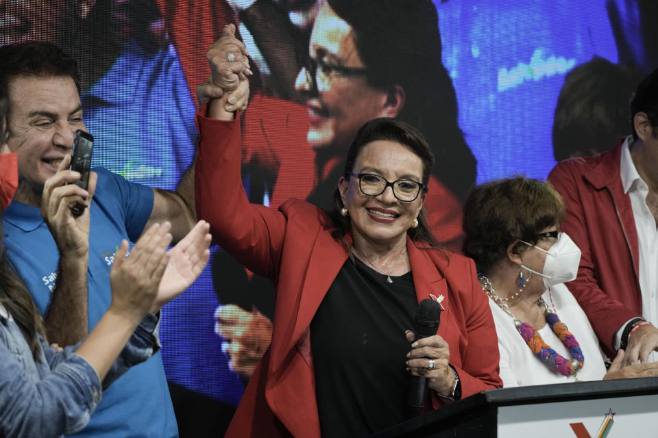 Free Party presidential candidate Xiomara Castro has her hand raised by her running mate Salvador Nasralla after general elections, in Tegucigalpa, Honduras, Sunday, Nov. 28, 2021. Castro claimed victory, setting up a showdown with the National Party which said its candidate had won a vote that could end the conservative party's 12 years in power. (AP Photo/Moises Castillo)