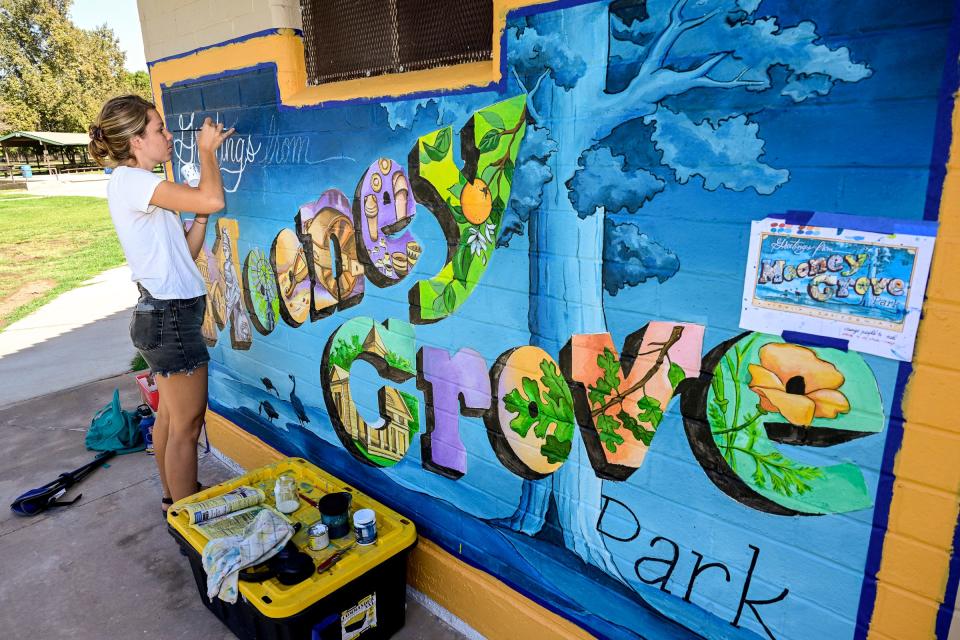 Katy Kemalyan finishes one of five new murals on Monday, October 3, 2022, all by different artists, at Mooney Grove Park.