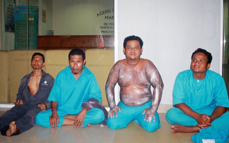 Image provided by the Malaysian Maritime Enforcement Agency shows passengers rescued from an overturned boat off the Johor coast waiting at the maritime office, on August 2, 2013. The rescuers on Sunday said hopes were fading for 40 Indonesians still missing