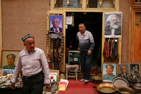 Portraits of China's late Chairman Mao Zedong, Soviet state founder Vladimir Lenin and German philosopher Karl Marx are displayed outside an antique shop in the old town in Kashgar, Xinjiang Uighur Autonomous Region, China, March 22, 2017. REUTERS/Thomas Peter