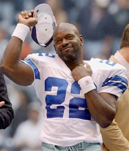 Cowboys running back Emmitt Smith tips his hat during a postgame ceremony after he broke the NFL all-time career rushing record against the Seattle Seahawks in 2002.