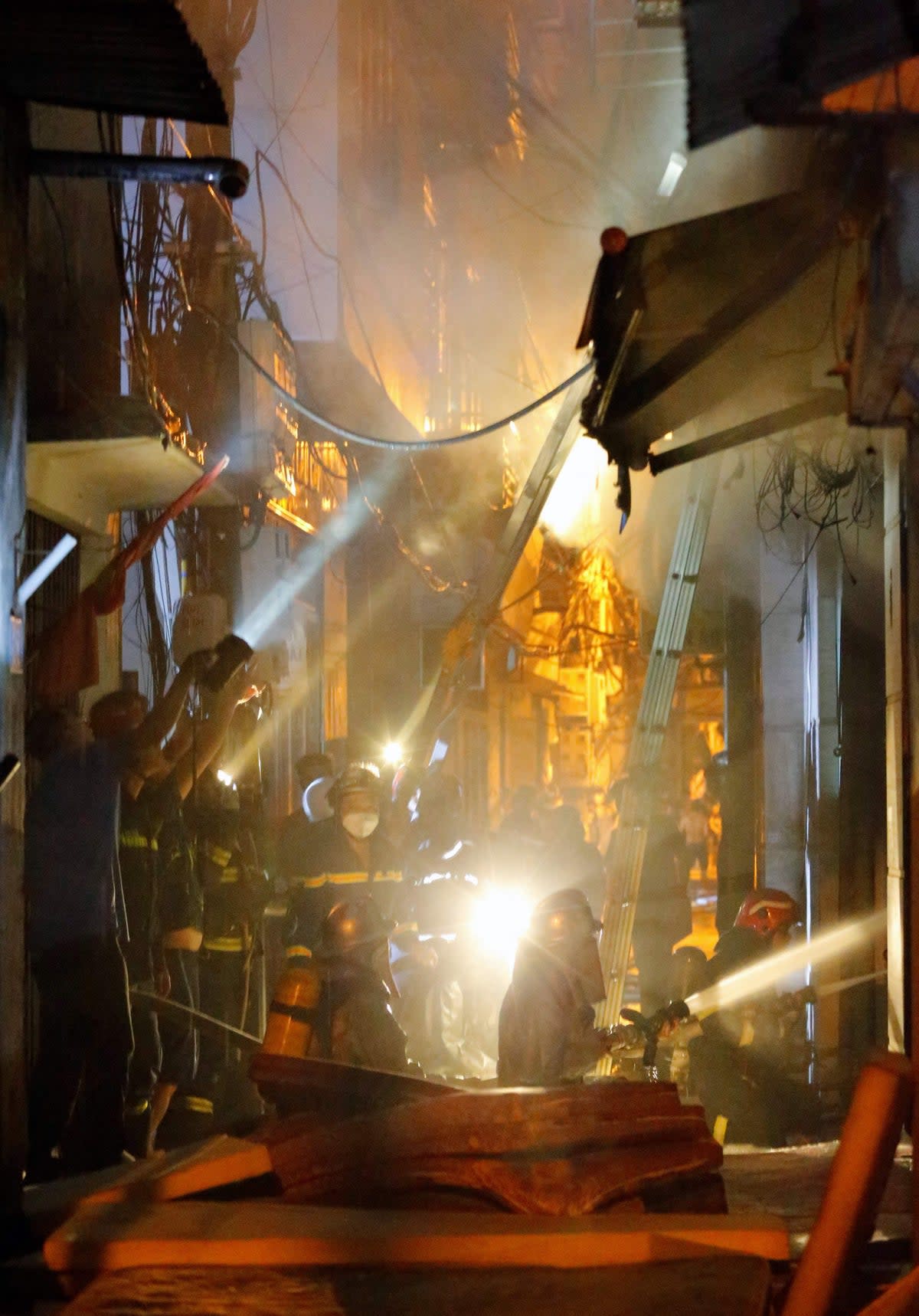 Firefighters work to put out a fire and rescue people at an apartment block in Hanoi (AFP via Getty Images)