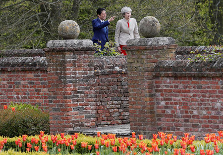 Britain's Prime Minister Theresa May shows Prime Minister Shinzo Abe of Japan around the garden during a visit to Chequers, near Wendover, Britain April 28, 2017. REUTERS/Kirsty Wigglesworth/Pool