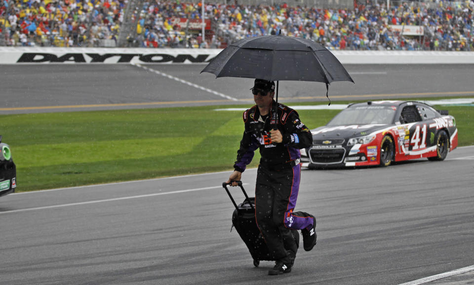 A crew member runs down pit road during a rain delay in the NASCAR Daytona 500 Sprint Cup series auto race at Daytona International Speedway in Daytona Beach, Fla., Sunday, Feb. 23, 2014. (AP Photo/Terry Renna)