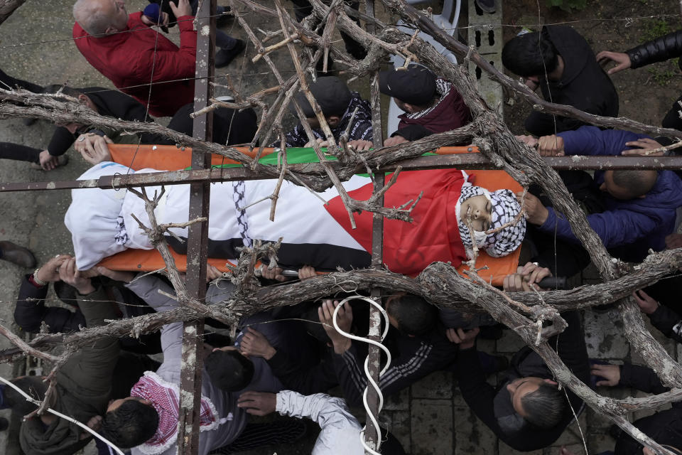 Palestinian mourners carry the body of Nader Rayan, 16, who was killed by Israeli forces during a raid at Balata refugee camp, during his funeral in the Balata refugee camp near the West Bank city of Nablus, Tuesday, March 15, 2022. (AP Photo/Majdi Mohammed)