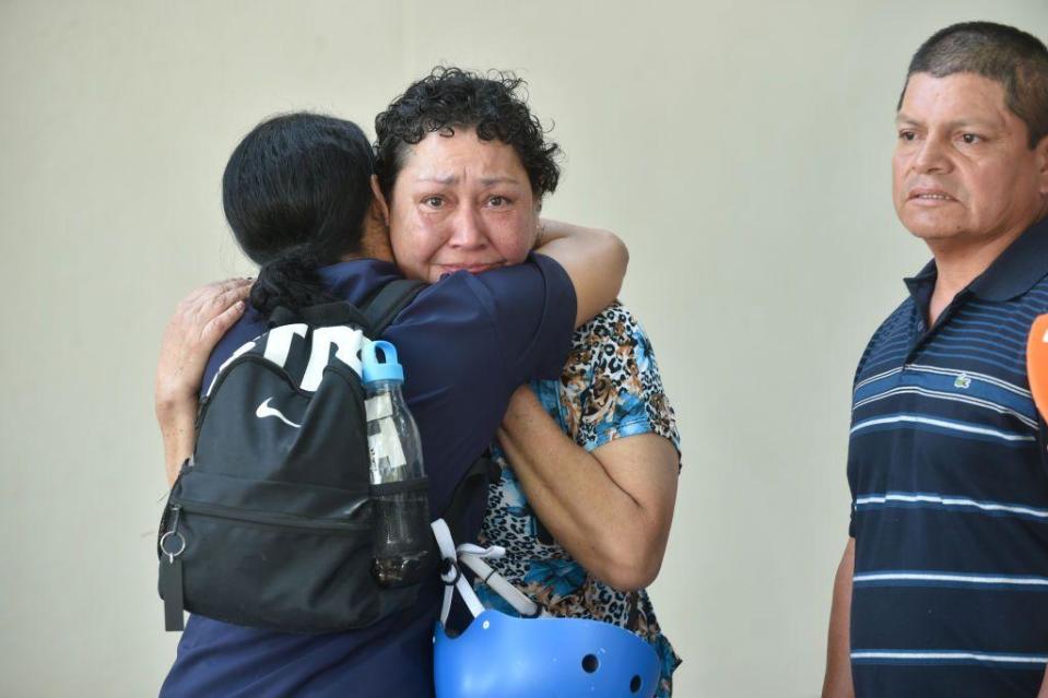 Un hombre abraza a una mujer que mira a cámara muy desolada. 