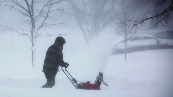 PHOTO: A person clears snow as a winter storm rolls through Western New York, Dec. 24, 2022, in Amherst N.Y. (Jeffrey T. Barnes/AP)