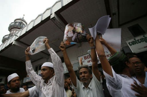 Myanmar Muslim men in Yangon on June 5, 2012 hold up pictures of recent violence in western Rakhine state during a gathering. Membres of the Muslim minority protested in downtown Yangon after an angry mob killed 10 Muslims and a crowd attacked a police station in a surge in sectarian tensions in the west of the country