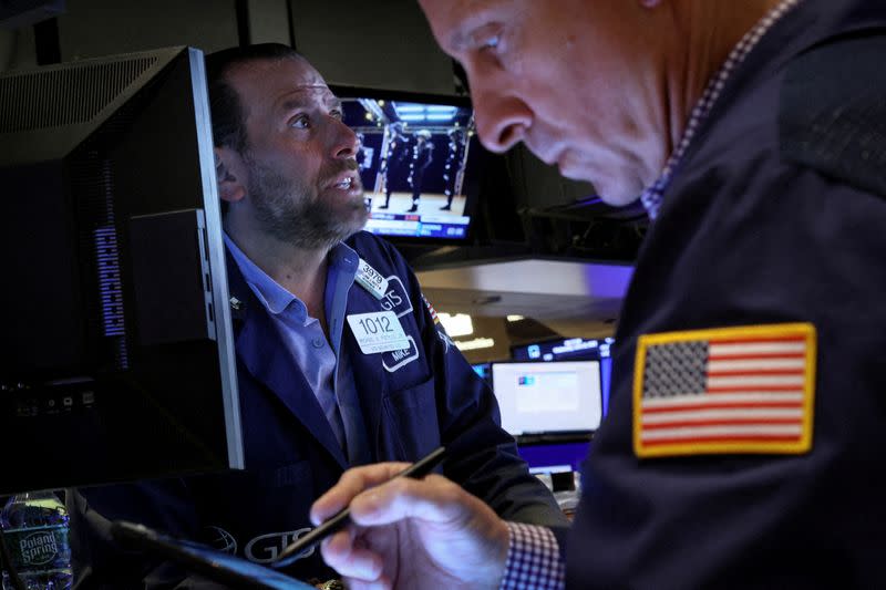 FILE PHOTO: Traders work on the floor of the NYSE in New York