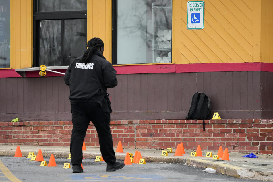FILE - A backpack is seen near evidence markers as a forensics official investigates at the site of a shooting near Edmondson Westside High School, Jan. 4, 2023, in Baltimore. In response to rising youth violence, Baltimore leaders are ramping up efforts to de-escalate conflicts between young people and protect students going to and from school. (AP Photo/Julio Cortez, file)