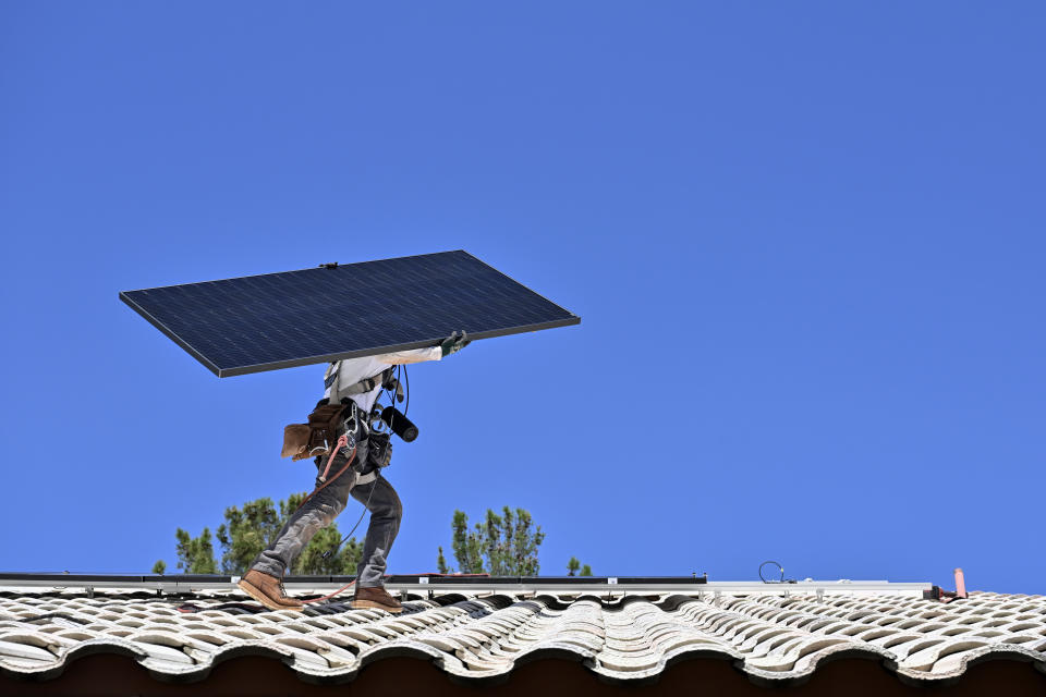 LAS VEGAS, NV - AUGUST 24: A Sunrun worker carries a solar panel for installation on the roof of William and Marcia Lee' home on August 24, 2023, in Las Vegas. (Photo by David Becker for the Washington Post)