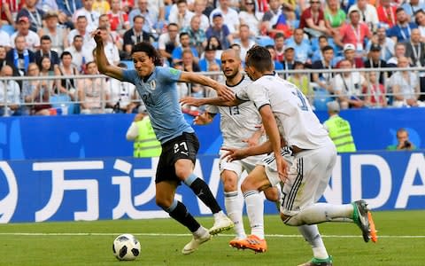 Uruguay's Edinson Cavani, left, take the ball away from Russia's Ilya Kutepov, right, and Fyodor Kudryashov during the group A match between Uruguay and Russia at the 2018 soccer World Cup at the Samara Arena in Samara, Russia, Monday, June 25, 2018 - Credit: AP