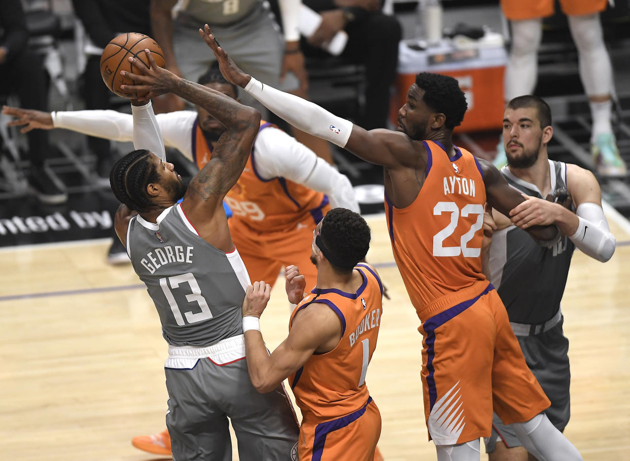 LOS ANGELES, CALIFORNIA - JUNE 26: Paul George #13 of the LA Clippers shoots under pressure from Devin Booker #1 and Deandre Ayton #22 of the Phoenix Suns during the first quarter in game four of the Western Conference Finals at Staples Center on June 26, 2021 in Los Angeles, California. NOTE TO USER: User expressly acknowledges and agrees that, by downloading and or using this photograph, User is consenting to the terms and conditions of the Getty Images License  (Photo by Kevork Djansezian/Getty Images)