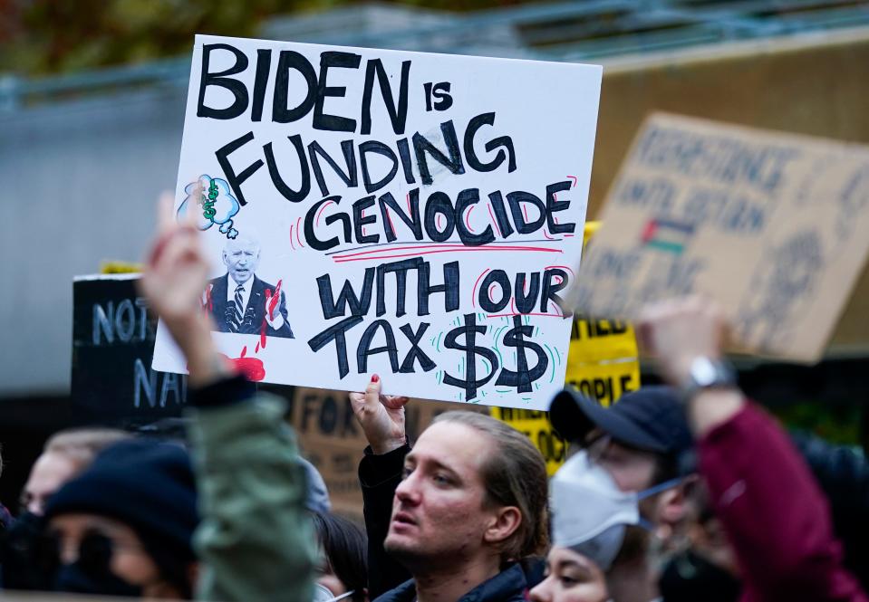 A participant holds a sign referencing President Joe Biden during a pro-Palestinian rally and march Saturday, Oct. 21, 2023, in Seattle.