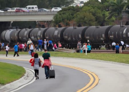 People exit the airport perimeter following a shooting incident at Fort Lauderdale-Hollywood International Airport in Fort Lauderdale, Florida, U.S. January 6, 2017. REUTERS/Andrew Innerarity