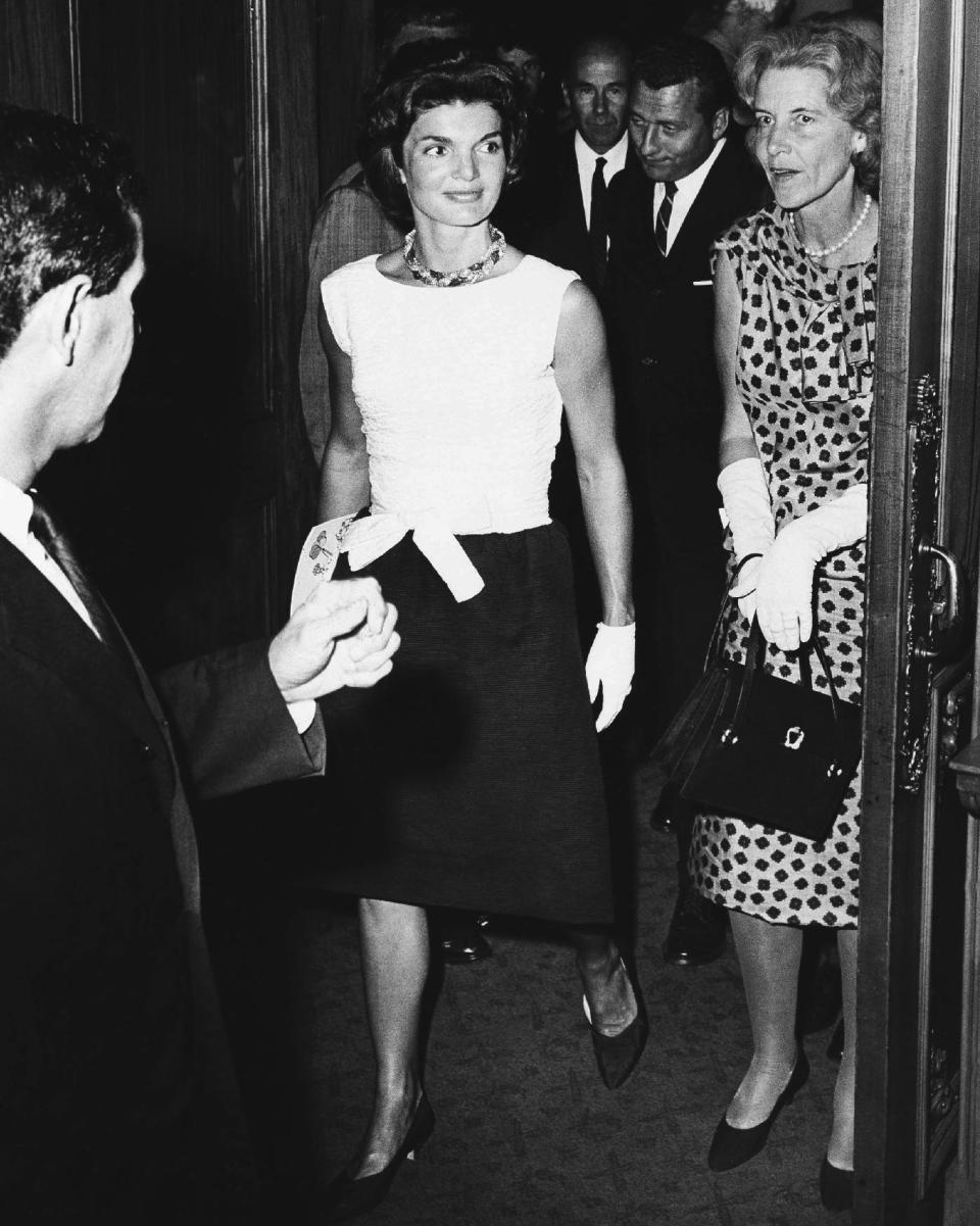 FILE - In this Aug. 17, 1961, file photo, Jacqueline Kennedy and her Cape Cod neighbor Bunny Mellon step into the lobby of the Colonial Theatre in Boston during intermission of Noel Coward’s new musical “Sail Away.” Mellon, a wealthy arts and fashion patron, friend of first lady Jacqueline Kennedy and political benefactor who funneled hundreds of thousands of dollars to former presidential candidate John Edwards that was used to hide his mistress, died Monday, March 17, 2014. She was 103. (AP Photo/File)