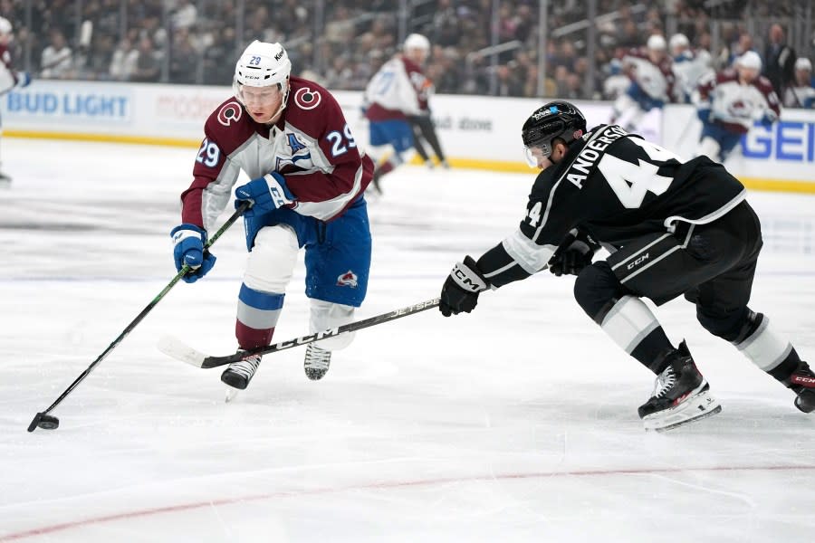 Colorado Avalanche center Nathan MacKinnon, left, moves the puck as Los Angeles Kings defenseman Mikey Anderson reaches in during the first period of an NHL hockey game Wednesday, Oct. 11, 2023, in Los Angeles. (AP Photo/Mark J. Terrill)