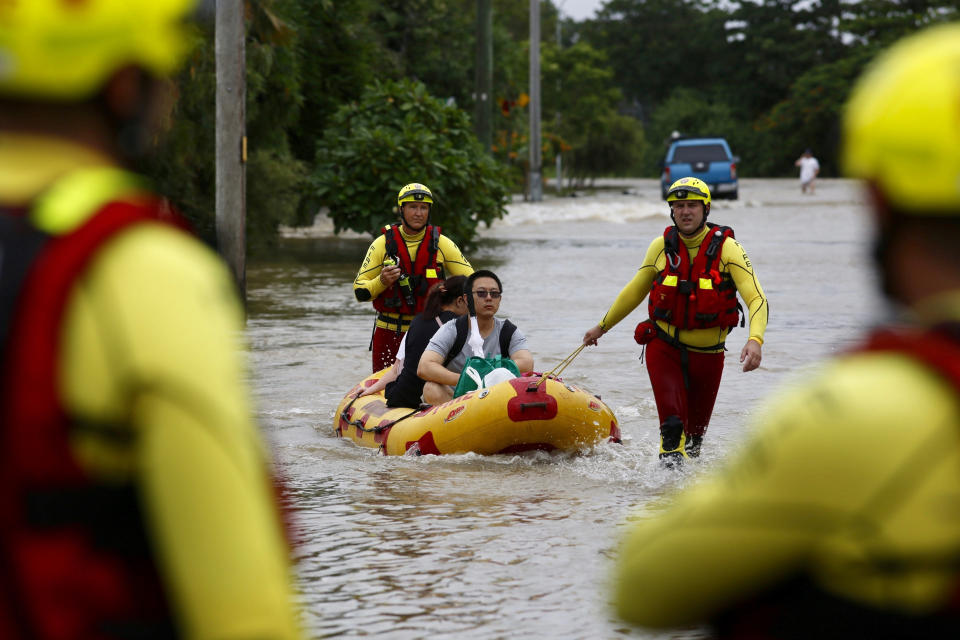 In this Sunday, Feb. 3, 2019, photo, Queensland Fire and Emergency Services crew members use an inflatable boat to pull residents through floodwaters at Hermit Park in Townsville, Australia. Emergency workers are using boats and helicopters to rescue people from flooded parts of northern Australia where forecasts call for more heavy rainfall. More than 1,100 people had been rescued from their homes on Sunday night and evacuation efforts were continuing Monday. (Andrew Rankin/AAP Image)