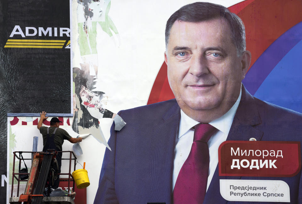 FILE - A worker removes a pre-election billboard showing Bosnian Serb leader Milorad Dodik, who chose to run for the president of Bosnia's Serb-run part, a day after a general elections in the Bosnian town of Banja Luka, 240 kms northwest of Sarajevo, on Oct. 3, 2022. U.S. Secretary of State Antony Blinken has compared the policies of separatist leader of the Serbs in Bosnia to those of Russian President Vladimir Putin following his moves to curb dissent and LGBTQ rights. Blinken said on Twitter late on Wednesday that "Milorad Dodik's attacks on basic rights and freedoms in Republika Srpska show he is on President Putin's authoritarian path." (AP Photo/Darko Vojinovic, File)