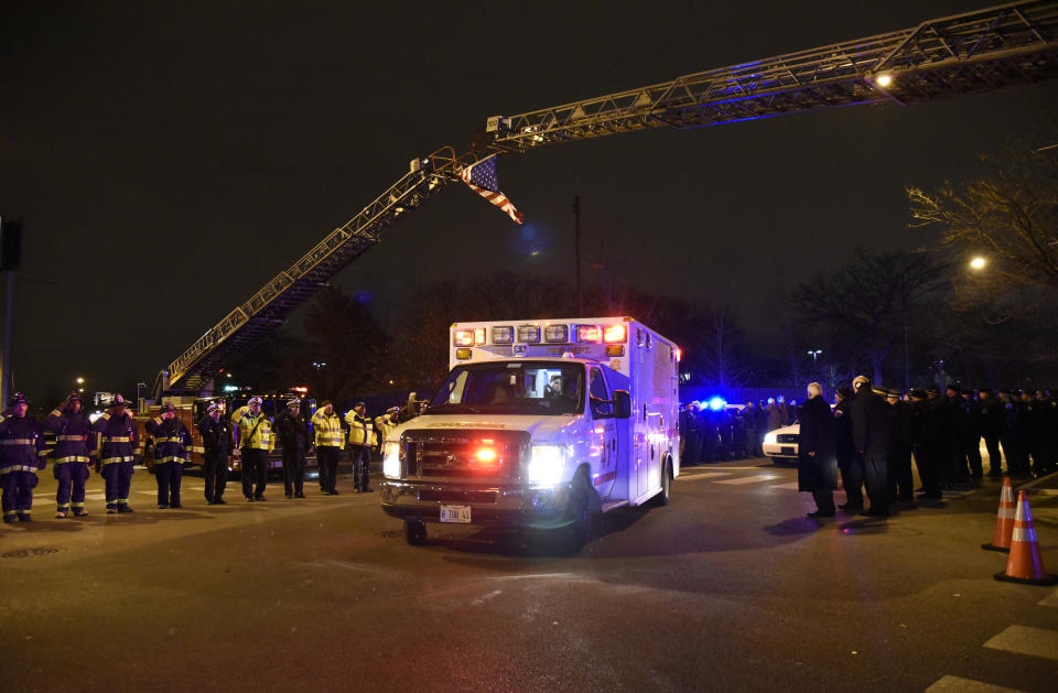 Chicago police officers and firefighters form an honor guard as the body of Chicago Police Officer Samuel Jimenez is brought to the coroner Monday, Nov. 19, 2018, in Chicago. A gunman opened fire Monday at a Chicago hospital, killing the police officer and at least a few hospital employees in an attack that began with a domestic dispute and exploded into a firefight with law enforcement inside the medical center. The suspect was also dead, authorities said. (AP Photo/David Banks)