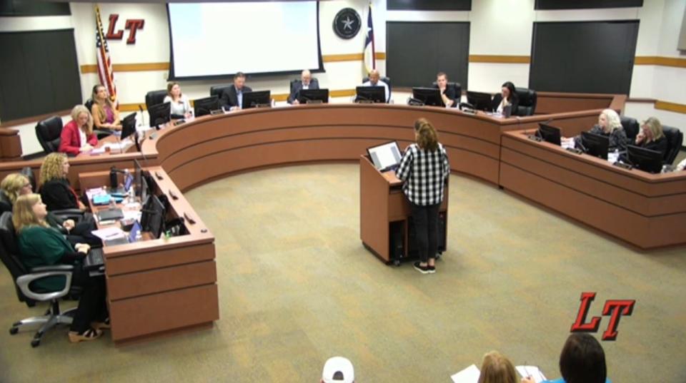 
            woman at podium speaks in front of school board

        