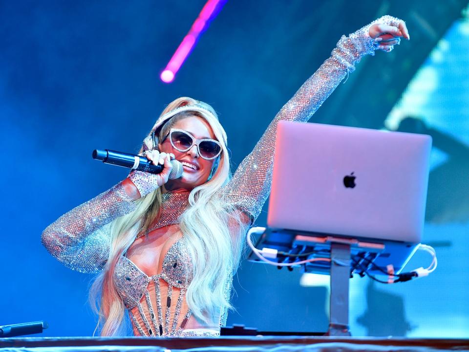 Paris Hilton holding a microphone and DJing