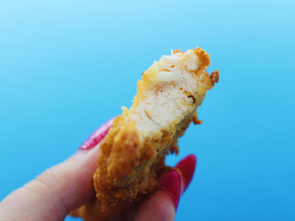 chick fil a chicken tender bitten into on blue background