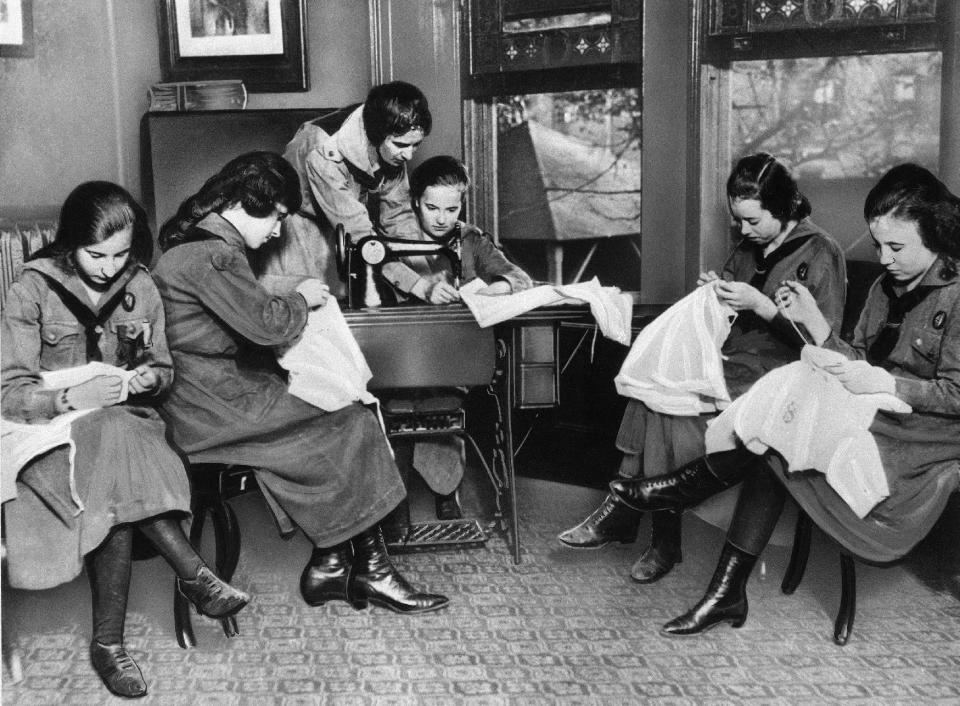 FILE - In this March 10, 1962 file photo, Girl Scouts learn to sew from their scout leader. It's been 100 years since Juliette Gordon Low recruited the first scouts in Georgia. Low's original registration book from March of 1912 shows 102 recruits. Now there are 2.3 million active Girl Scouts nationwide. (AP Photo/File)