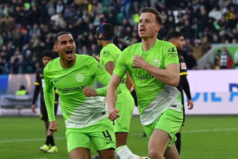 Wolfsburg's Yannick Gerhardt celebrates scoring his side's first goal with teammate Maxence Lacroix during the German Bundesliga soccer match between VfL Wolfsburg and Borussia Dortmund at the Volkswagen Arena. Swen Pförtner/dpa