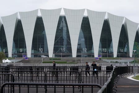 People are seen next to fences outside the venue that was scheduled to hold fan events ahead of an NBA China game between Brooklyn Nets and Los Angeles Lakers, at the Oriental Sports Center in Shanghai