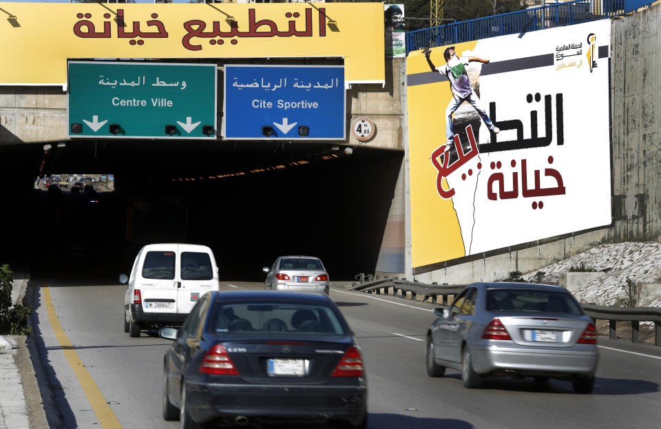 Cars pass next to an Arabic banner that reads: "Normalization (with Israel) is treason," set against the Arab economic development summit, at the airport highway where some of the Arab leaders who will attend the summit will pass by, in Beirut, Lebanon, Thursday, Jan. 17, 2019. The summit that Lebanon is hosting this weekend has been marred by controversy days before delegates arrive. (AP Photo/Hussein Malla)