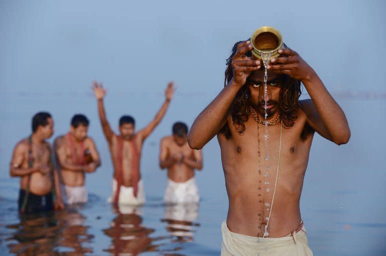 Hindu devotees pray as they bathe in the Sangam or confluence of the Yamuna, Ganges and mythical Saraswati rivers at the Kumbh Mela in Allahabad, on February 10, 2013