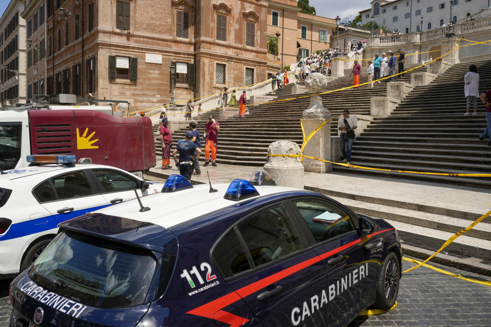 Rome municipality workers clean the Spanish Steps after activists dumped red paint over them protesting against violence on women, in Rome, Wednesday, June 26, 2024. (AP Photo/Andrew Medichini)