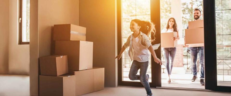 Happy family with cardboard boxes in new house at moving day.