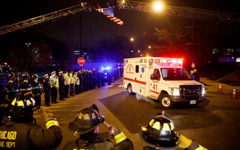 Police and firefighters salute as an ambulance arrives at the medical examiner's office carrying the body of Chicago Police Department Officer Samuel Jimenez, - Credit: Armando L. Sanchez/ Chicago Tribune