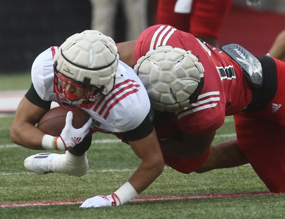 Isaac Guerendo (left) is tackled by Jackson Hamilton during Louisville's spring game on April 21, 2023.