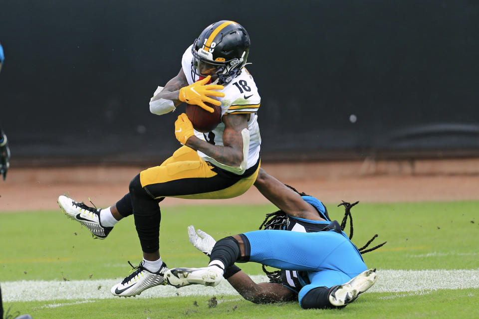 Pittsburgh Steelers wide receiver Diontae Johnson, left, makes a reception despite defensive effort by Jacksonville Jaguars cornerback Tre Herndon, right, during the first half of an NFL football game, Sunday, Nov. 22, 2020, in Jacksonville, Fla. (AP Photo/Matt Stamey)