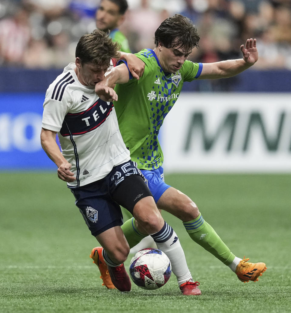 Vancouver Whitecaps' Ryan Gauld (25) and Seattle Sounders' Cody Baker vie for the ball during the second half of an MLS soccer match in Vancouver, British Columbia on Saturday, May 20, 2023. (Darryl Dyck/The Canadian Press via AP)