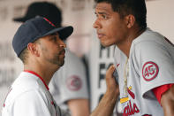 St. Louis Cardinals' bench coach Oliver Marmol talks to starting pitcher Johan Oviedo after he left the game in the fifth inning of a baseball game against the Cincinnati Reds in Cincinnati, Sunday, July 25, 2021. (AP Photo/Bryan Woolston)