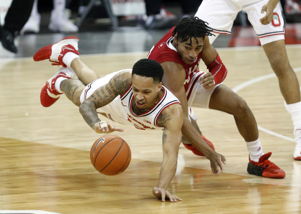Ohio State guard CJ Walker, left, dives for a loose ball against Indiana guard Armaan Franklin during the first half of an NCAA college basketball game in Columbus, Ohio, Saturday, Feb. 13, 2021. (AP Photo/Paul Vernon)