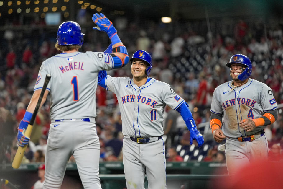 New York Mets' Jose Iglesias, center, celebrates after his two-run home run with Jeff McNeil, left, and Francisco Alvarez, right, during the 10th inning of a baseball game against the Washington Nationals at Nationals Park, Monday, July 1, 2024, in Washington. (AP Photo/Alex Brandon)