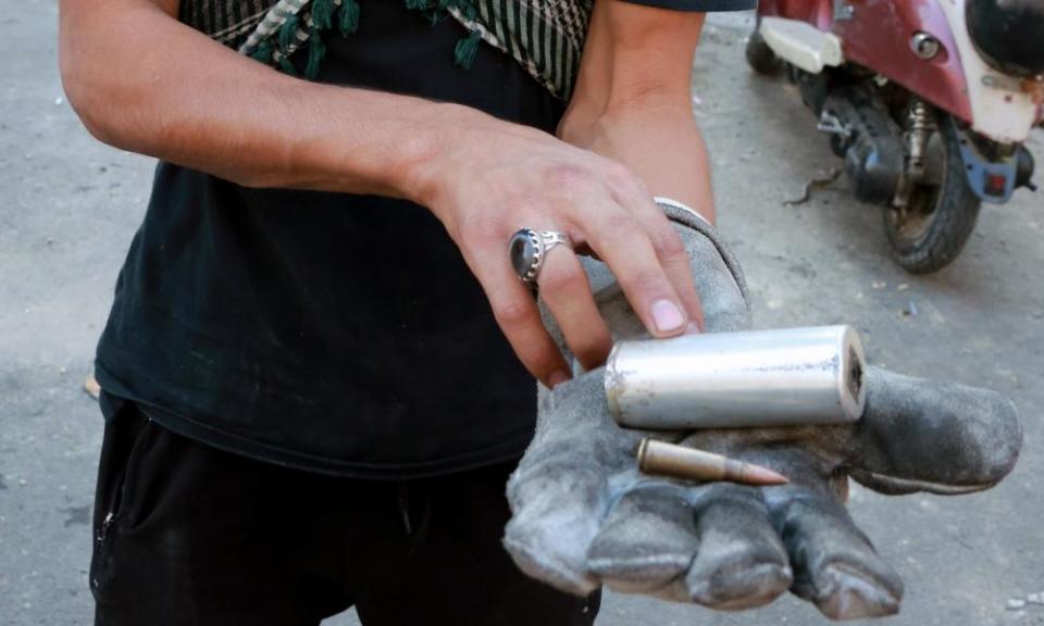 A protester holds a teargas canister fired by police