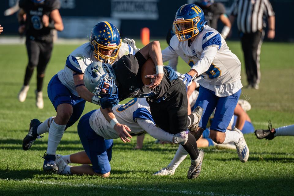 Worcester Tech's Liam Dancy is brought down by a group of Assabet defenders.