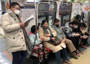 Man wearing a mask reads on the subway in Beijing