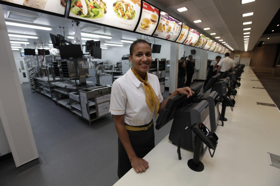 Rachel Lucian, assistant manager of the newly constructed McDonald's restaurant at the Olympic Park in east London, poses for the photographers, Monday, June 25, 2012. The restaurant is designed to be reusable and recyclable after the London 2012 Olympic and Paralympic Games. (AP Photo/Lefteris Pitarakis)