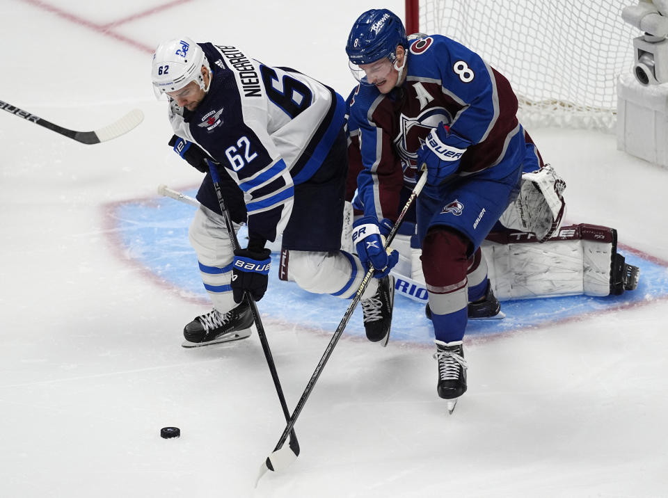Winnipeg Jets right wing Nino Niederreiter, left, and Colorado Avalanche defenseman Cale Makar vie for the puck during the third period of Game 3 of an NHL hockey Stanley Cup first-round playoff series Friday, April 26, 2024, in Denver. (AP Photo/David Zalubowski)