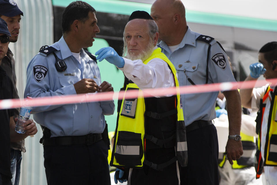 FILE - In this Oct. 13, 2015 file photo, Yehuda Meshi-Zahav, then head of Israel's ZAKA rescue service, center, stands stands at the scene of a shooting attack by a Palestinian gunman, in Jerusalem. On Sunday, March 14, 2021, the Israeli police announced that the force's major crimes unit, Lahav 433, had opened an investigation into sexual abuse allegations against Meshi-Zahav. In recent days, some 20 people have come forward with claims that he was a savage sexual predator who assaulted men, women and children for years. (AP Photo Oded Balilty, File)